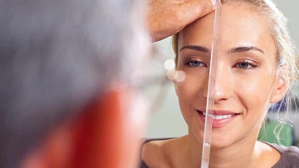 Woman having facial measurements taken for aesthetics.