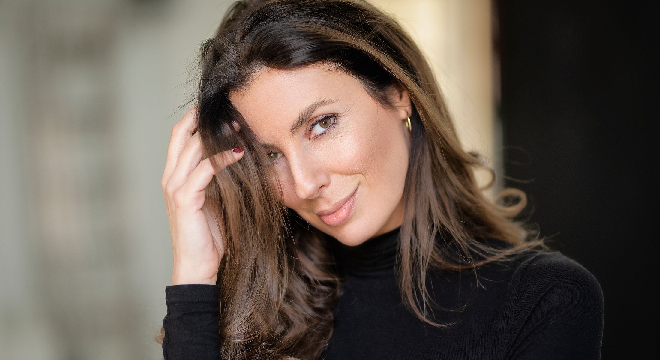 Woman smiling and touching her hair.