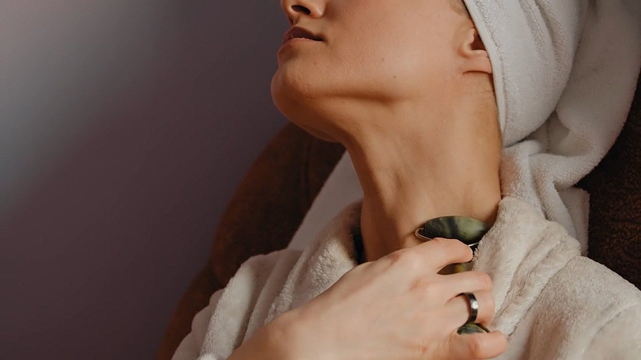 Woman using a jade roller for skincare.