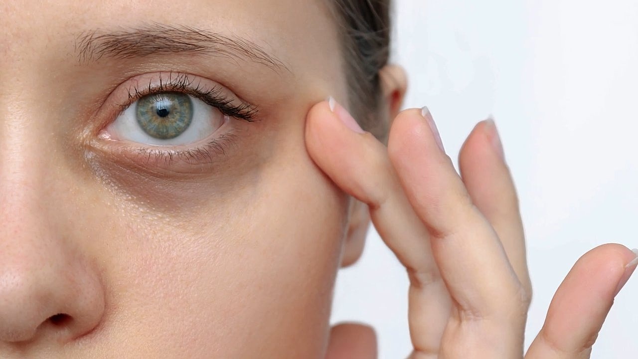 Close-up of a woman’s eye and hand.